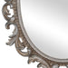 A vintage oval wall mirror with a decorative silver frame, designed for mounting on a wall.