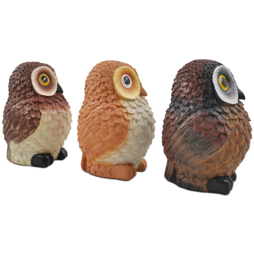A set of three resin owl figurines, painted in different colors, is displayed side by side.