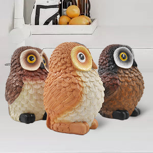 A set of three resin owl figurines, painted in different colors, is displayed side by side.