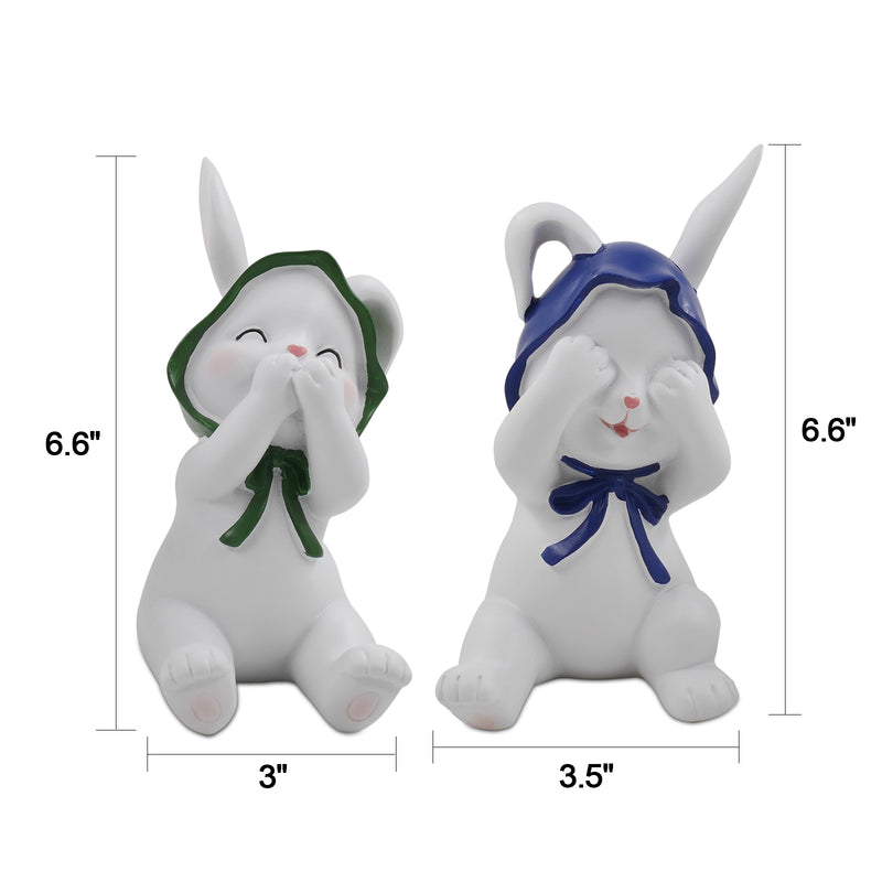 Two resin figurines of sitting rabbits with hats, one with eyes covered and one with a mouth covered, in different poses.