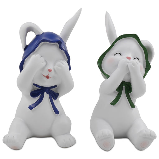 Two resin figurines of sitting rabbits with hats, one with eyes covered and one with a mouth covered, in different poses.