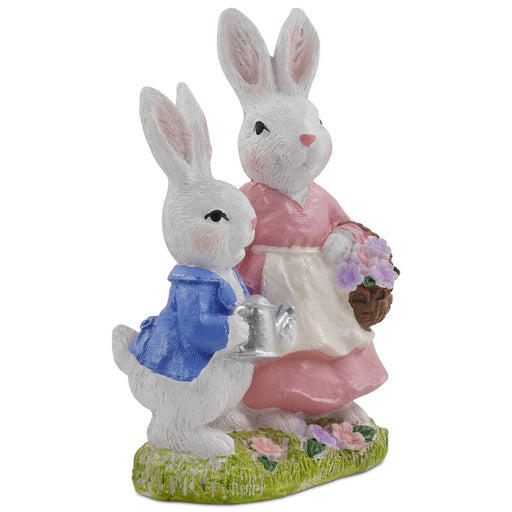 A hand-painted resin figurine of a rabbit family, comprising a mother and child, dressed in decorative outfits and holding a floral basket and a metal pot.