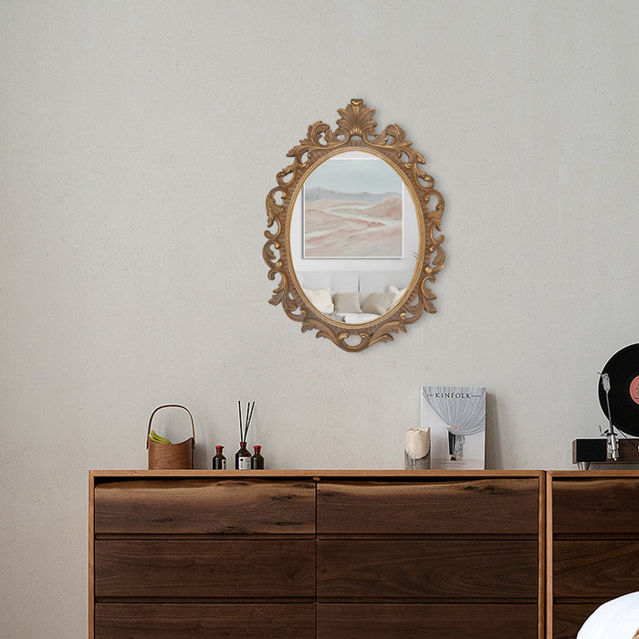 A vintage oval wall mirror with a decorative gold frame, designed for mounting on a wall.