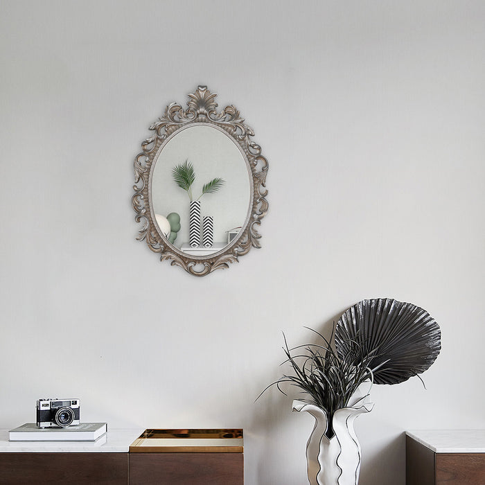 A vintage oval wall mirror with a decorative silver frame, designed for mounting on a wall.