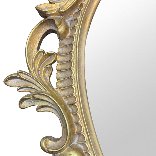 A vintage oval wall mirror with a decorative gold frame, designed for mounting on a wall.